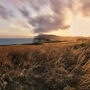 Winter view of Freshwater Bay on the Isle of Wight with cliffs, calm sea, and pebble beach under soft seasonal light.