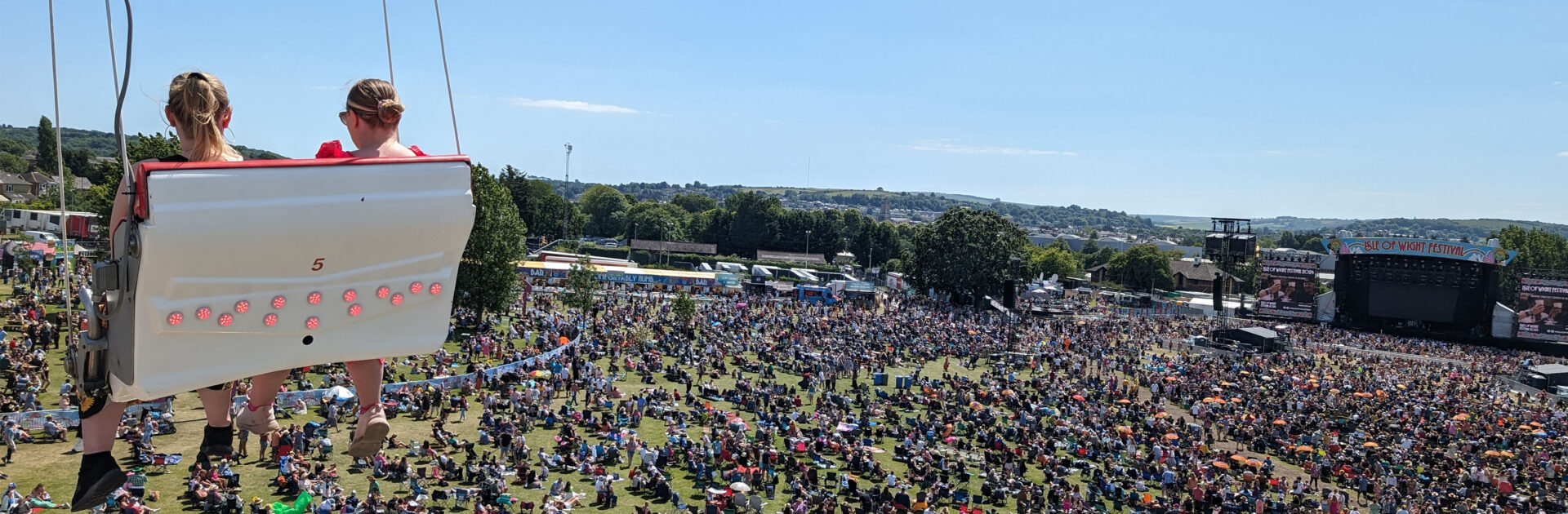 A vibrant crowd enjoying live music at the Isle of Wight Festival, perfect for guests staying in local Isle of Wight festival accommodation.