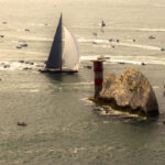 A massive fleet of sailing boats rounding the iconic Needles landmark during the annual Round the Island Race yacht regatta.