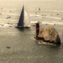 A massive fleet of sailing boats rounding the iconic Needles landmark during the annual Round the Island Race yacht regatta.