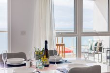 Modern dining area with table and chairs overlooking the sea at Culver Sands, Isle of Wight