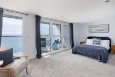 Spacious bedroom opening onto balcony with ocean views at Culver Sands, Isle of Wight