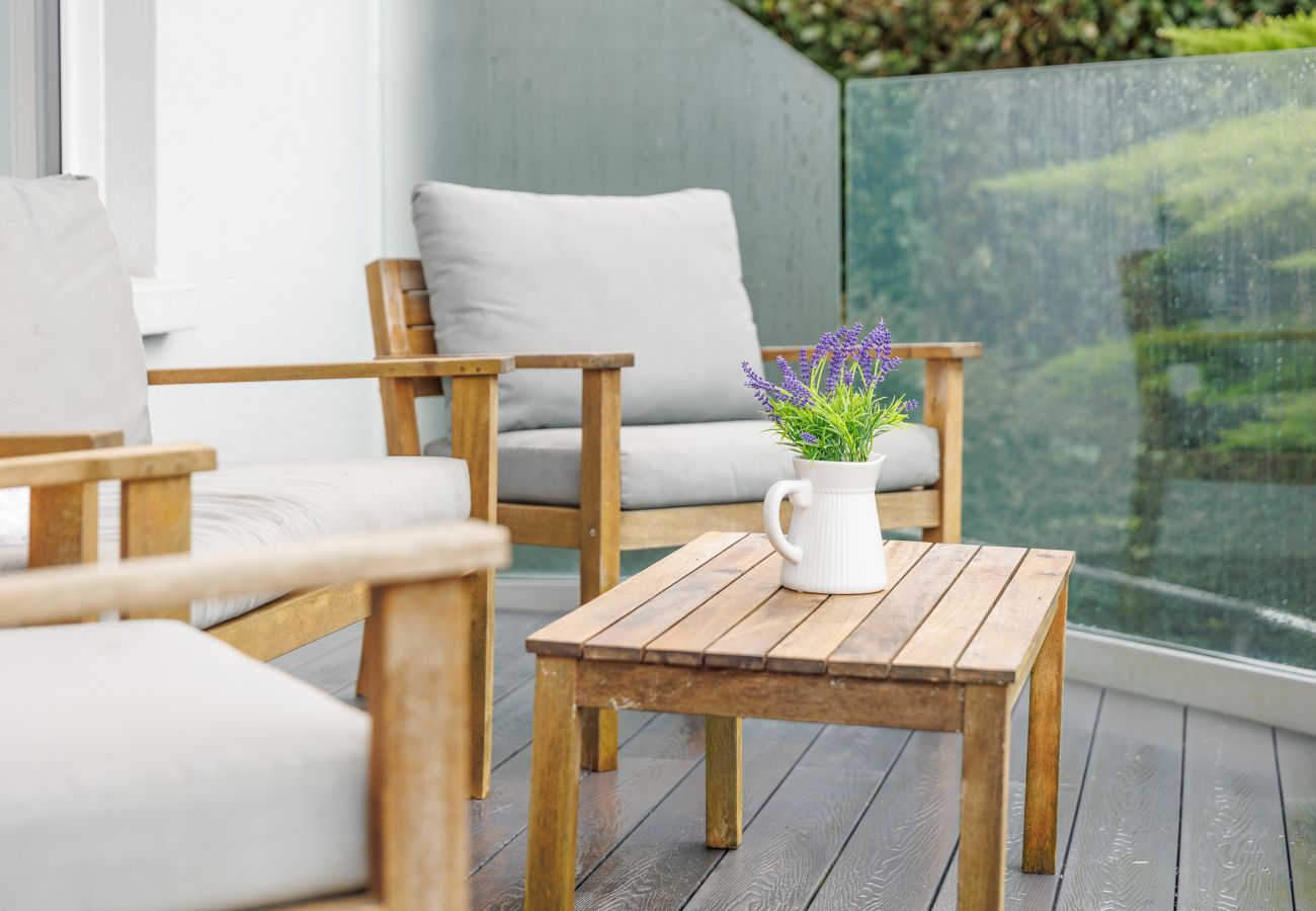 Guests enjoying morning coffee on balcony seating at Cowes Garden Apartment