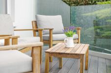 Guests enjoying morning coffee on balcony seating at Cowes Garden Apartment