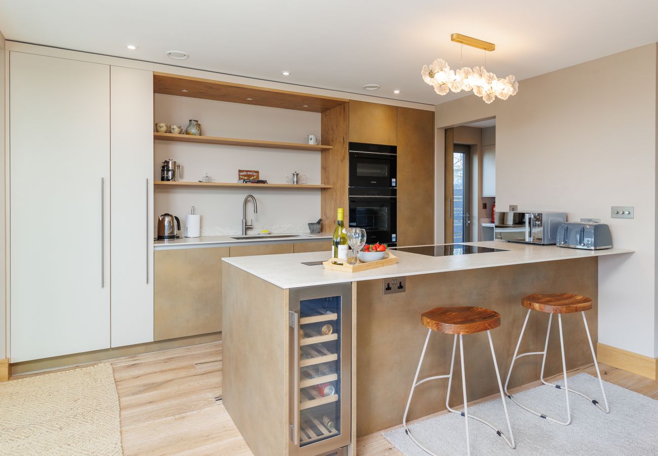 Contemporary fully equipped kitchen at Rena’s Retreat with high-spec appliances, sleek cabinetry, and open-plan access to dining and living areas