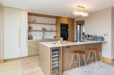 Contemporary fully equipped kitchen at Rena’s Retreat with high-spec appliances, sleek cabinetry, and open-plan access to dining and living areas