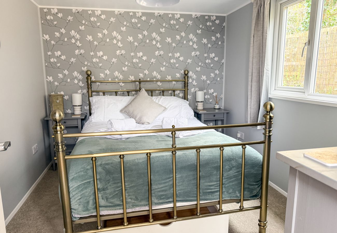 Comfortable double bedroom at Red Cedars with Freeview TV, modern furnishings, and coastal-inspired décor, perfect for relaxing stays