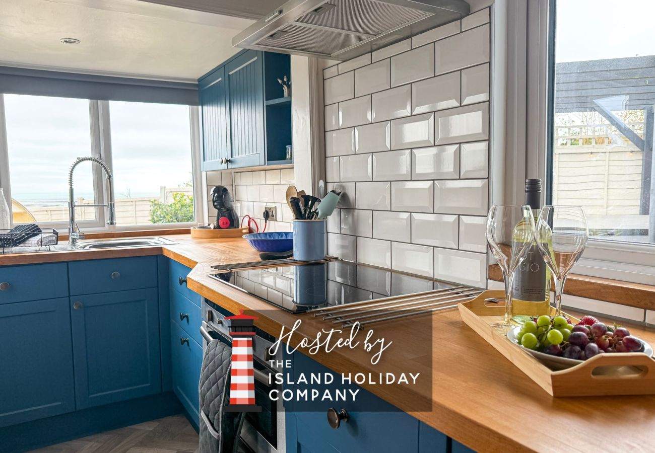Modern kitchen at Red Cedars with high-spec appliances and sink area overlooking coastal scenery, perfect for cooking with a view