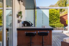 Outdoor barbecue and seating area in coastal holiday property