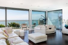 Open plan living room with balcony and sea views in coastal holiday home