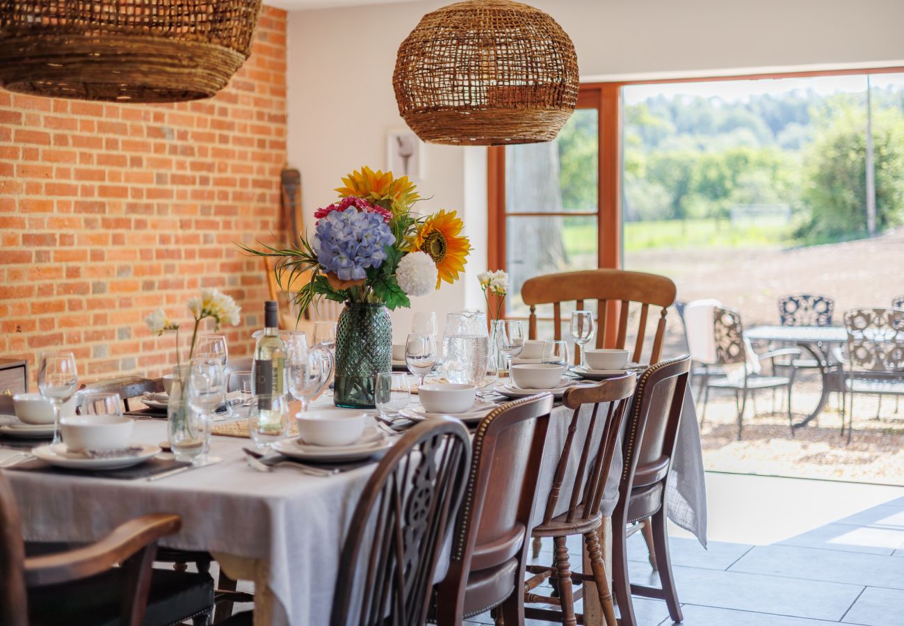 Large dining room with double doors opening onto the garden and BBQ area at The Farmhouse at Nunwell