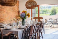 Large dining room with double doors opening onto the garden and BBQ area at The Farmhouse at Nunwell