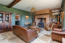 Spacious living area with log burner at The Farmhouse at Nunwell holiday home on the Isle of Wight