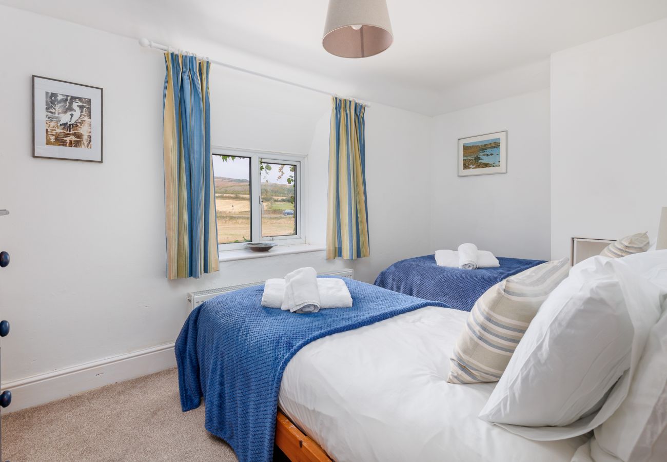 Twin bedroom with blue features and countryside views at Moon Chine Cottage on the Isle of Wight.