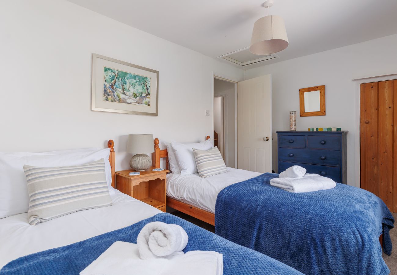 Twin bedroom with blue features at Moon Chine Cottage, viewed from the opposite side of the room.