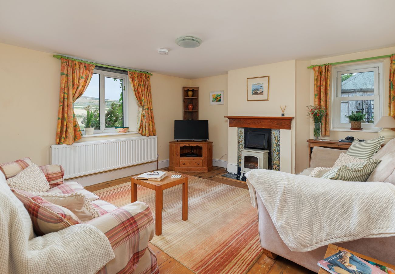 Cosy living room at Moon Chine Cottage with a TV, electric log burner and countryside views.