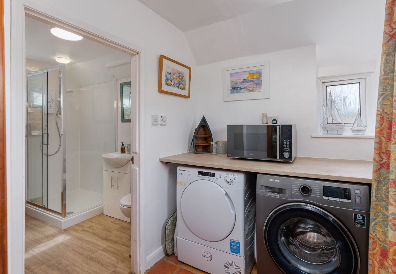 Utility area with washing machine and tumble dryer at Moon Chine Cottage on the Isle of Wight.
