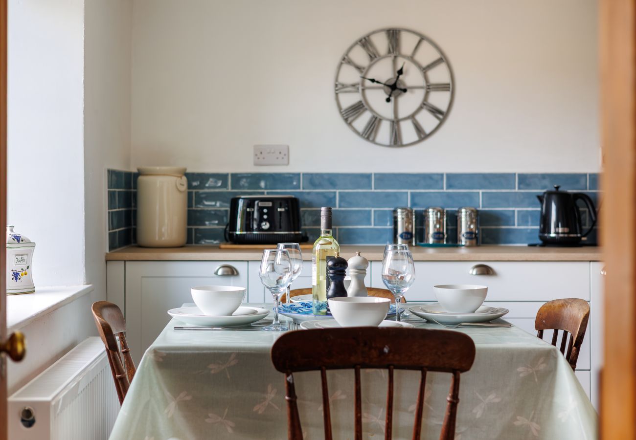 Dining table set for dinner at Moon Chine Cottage with countryside views on the Isle of Wight.