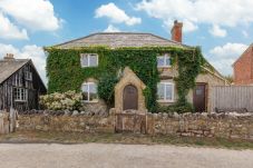 Front exterior of Moon Chine Cottage surrounded by peaceful countryside on the Isle of Wight.