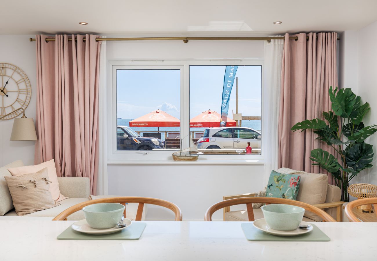 Kitchen and living space at Hummingbird with a sea view through the window while preparing dinner.
