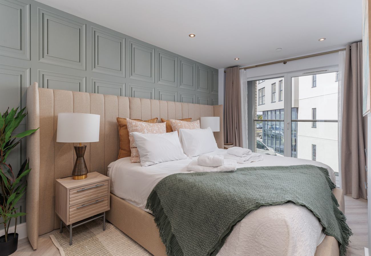 Master bedroom with a comfortable super king-size bed at Hummingbird, a ground-floor apartment on Sandown seafront.