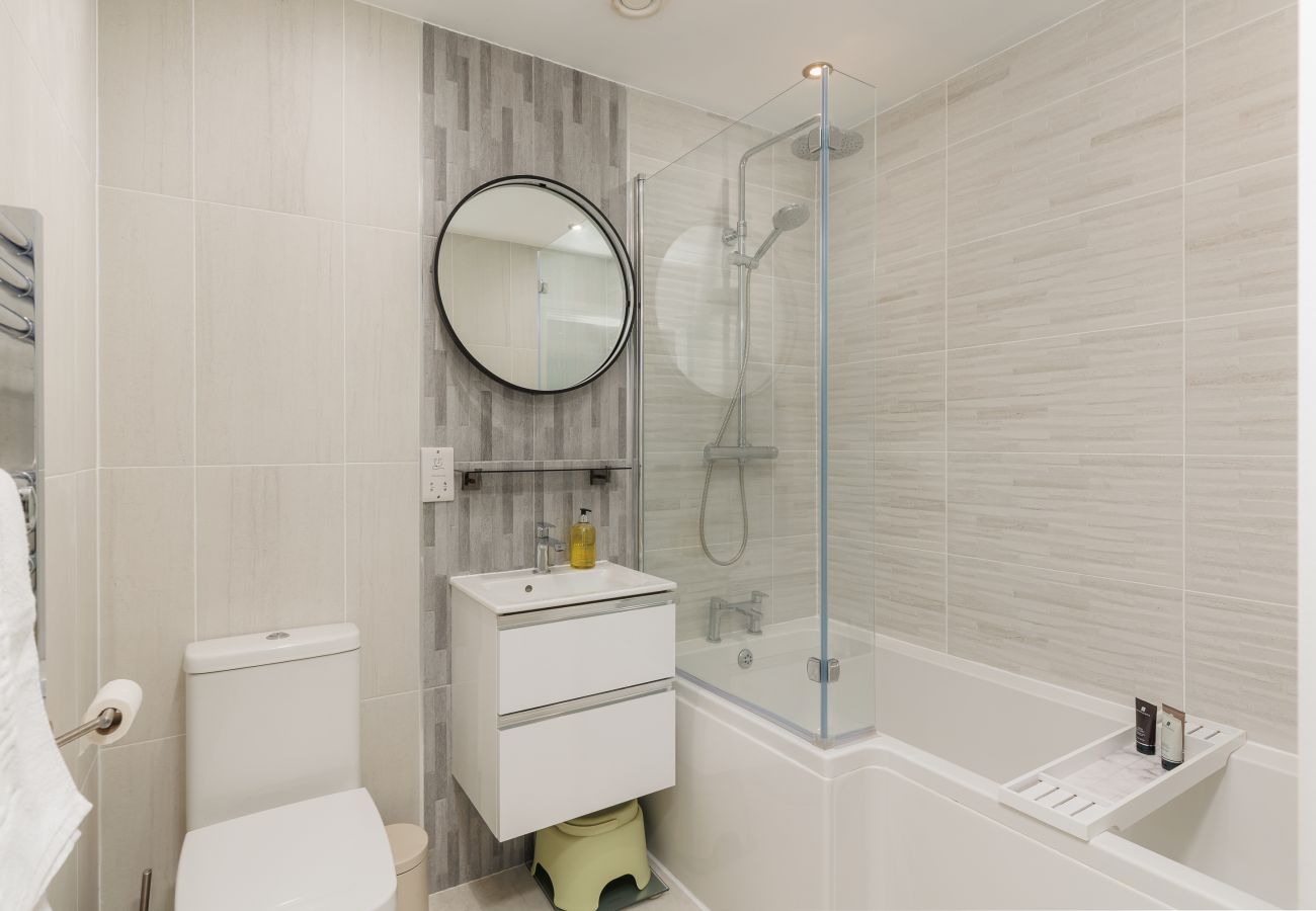 Family bathroom with a bath and shower over the bath at Hummingbird, Sandown seafront.