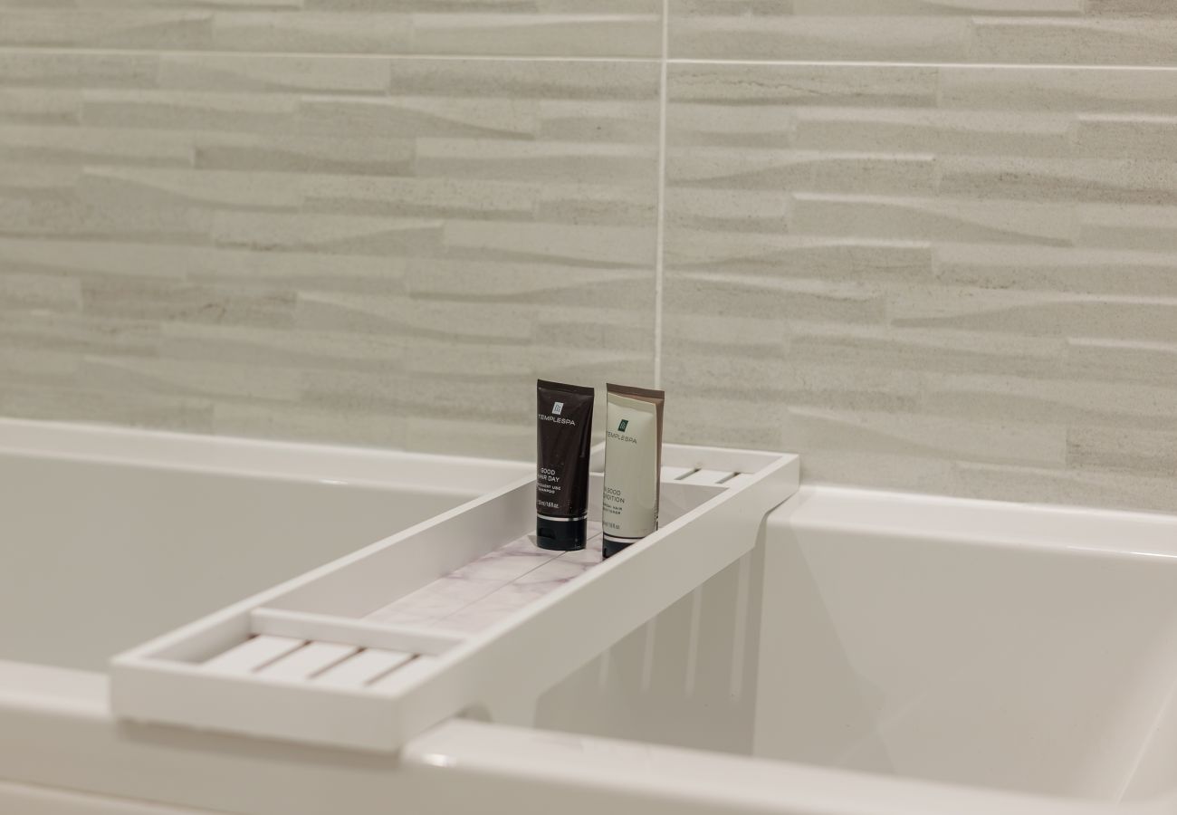 Temple Spa toiletries displayed beside the bath in the family bathroom at Hummingbird, Sandown.