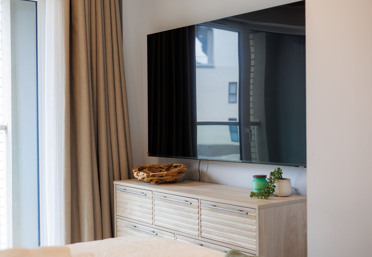 Television in the master bedroom at Hummingbird, featuring a super king-size bed.